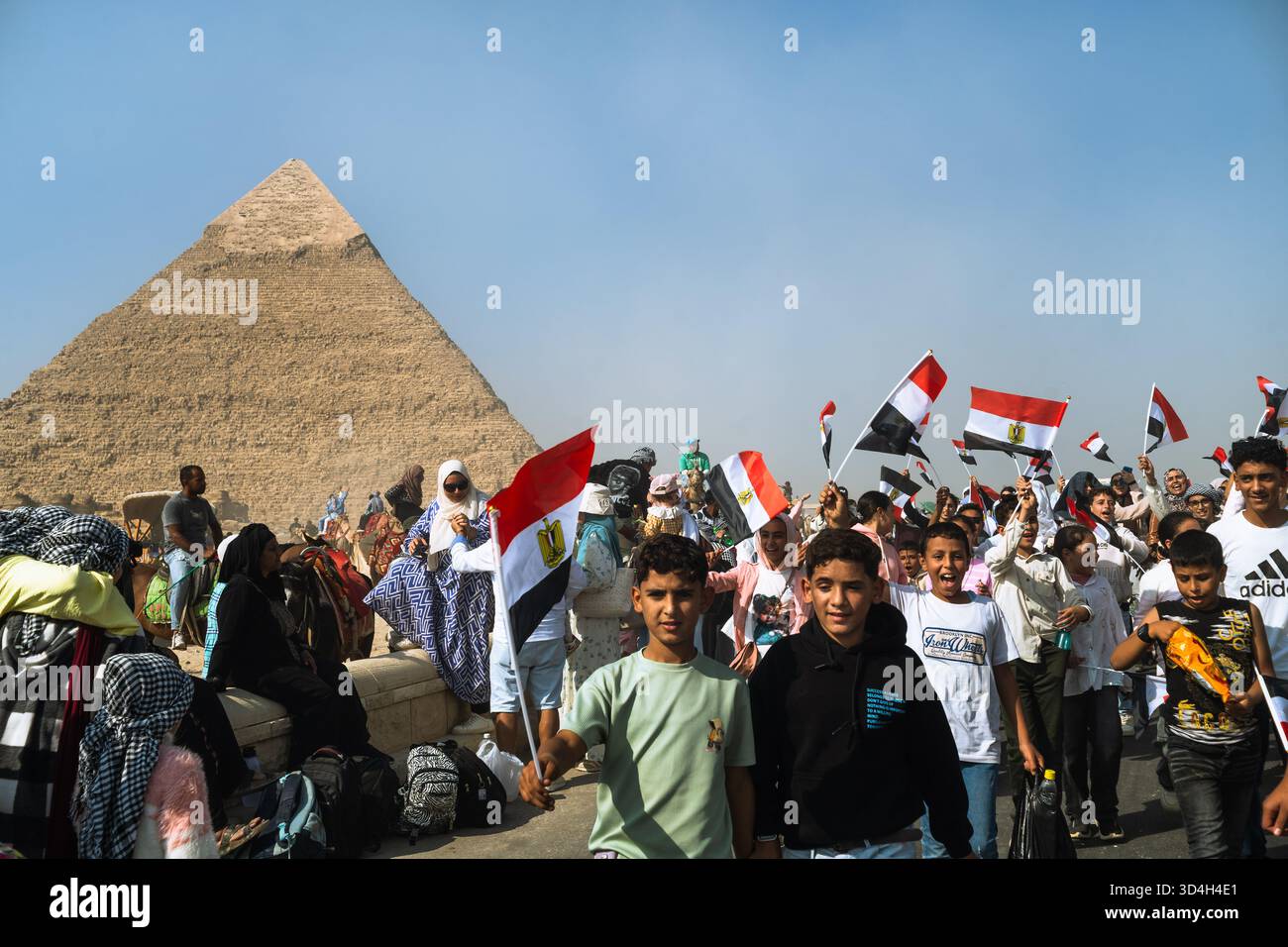 Les jeunes égyptiens tiennent le drapeau égyptien lors d'une excursion d'une journée scolaire dans le complexe des pyramides Banque D'Images