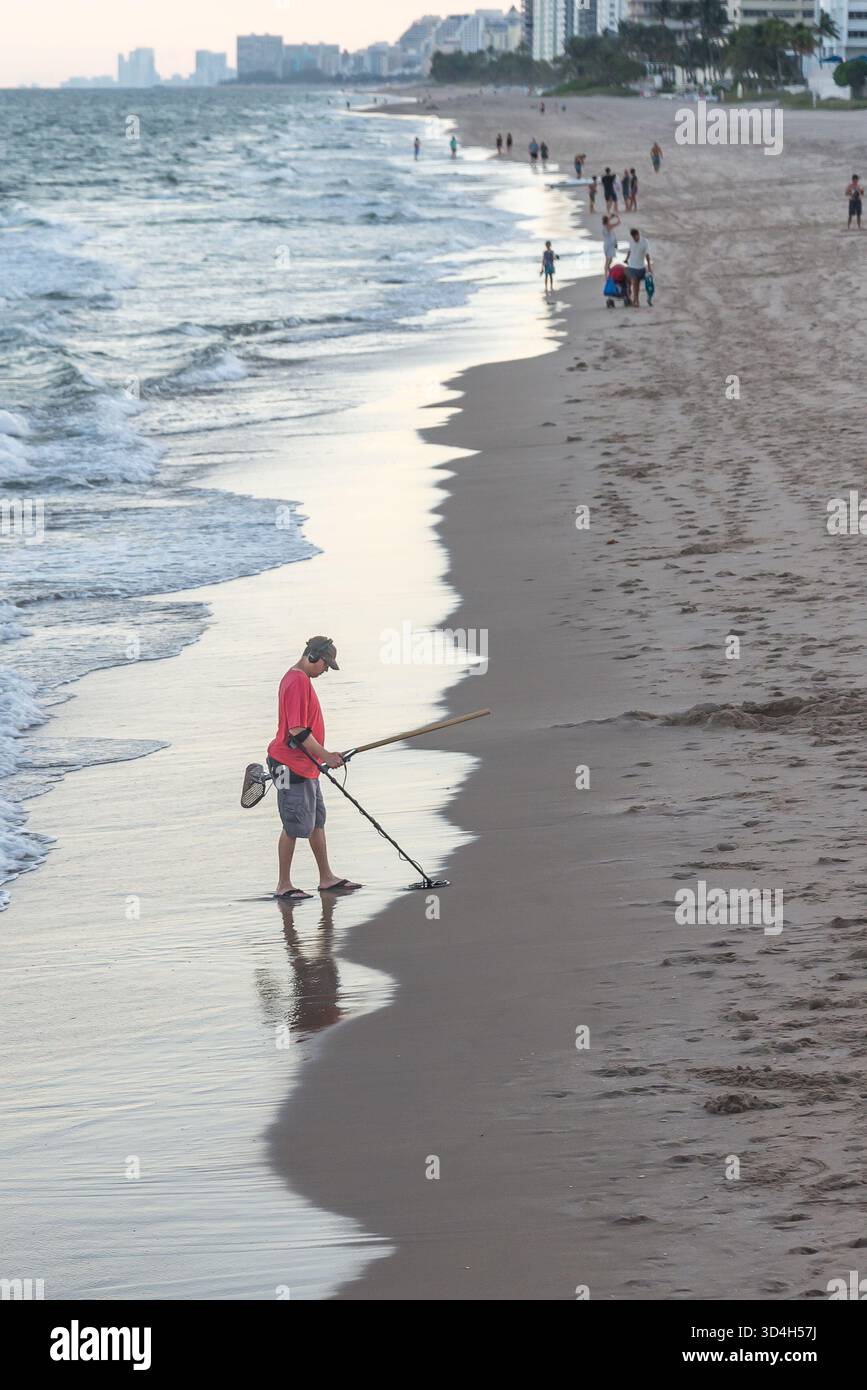 Beach Comer utilisant le détecteur de métaux pour trouver le trésor perdu. Banque D'Images