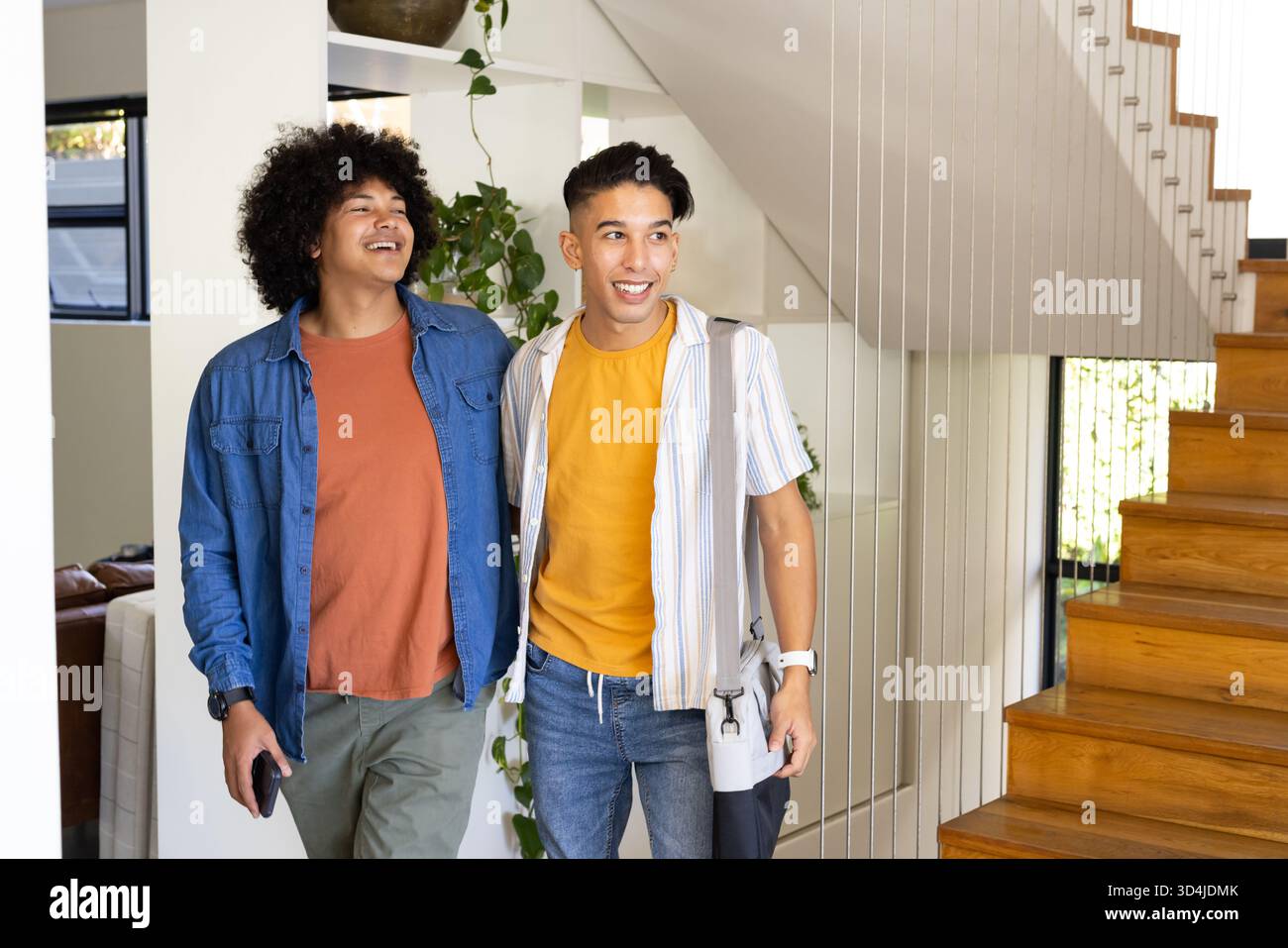 Marcher divers amis masculins portant smartphone et sac à dos dans l'entrée moderne, avec bouteille d'eau Banque D'Images