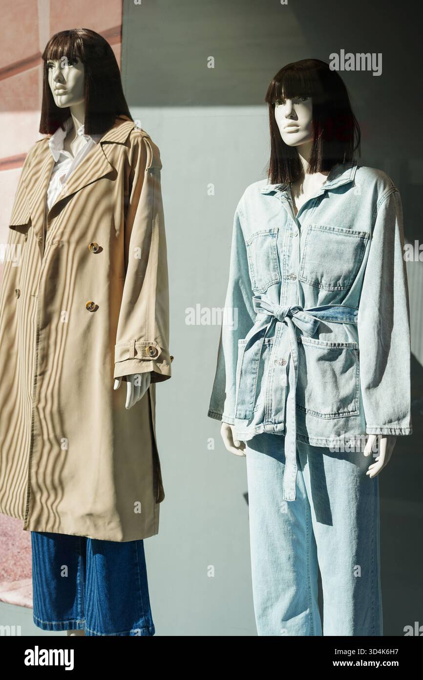 Deux mannequins féminins vêtus d'un trench décontracté et d'une tenue en denim en vitrine Banque D'Images