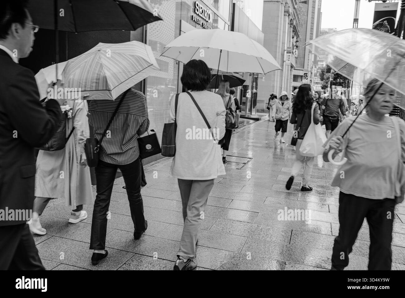 Les piétons descendent une avenue dans le quartier commerçant populaire de Ginza, Tokyo, Japon Banque D'Images