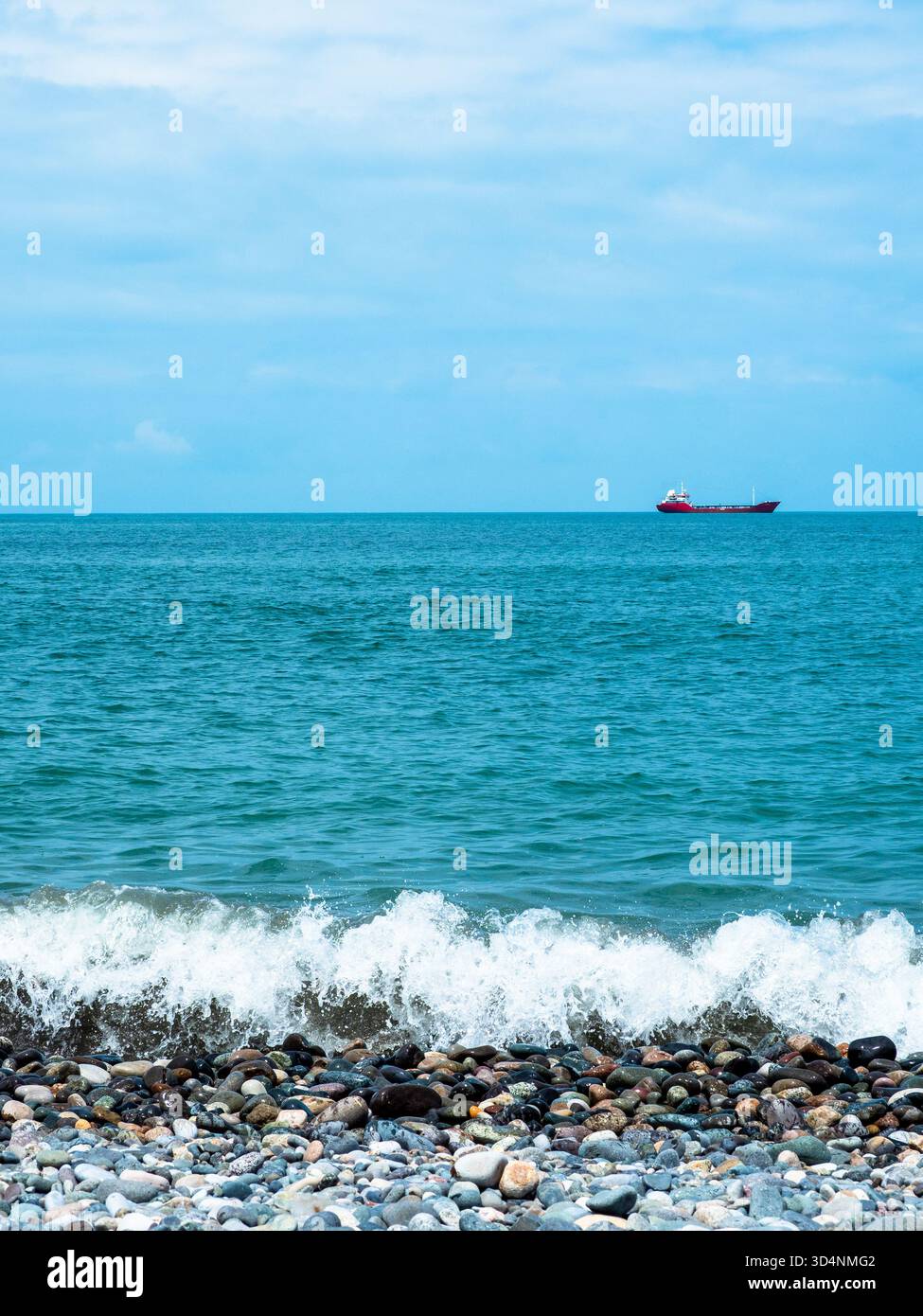 Vue sur l'eau de la mer Noire avec bateau de la plage de galets à Batumi Banque D'Images
