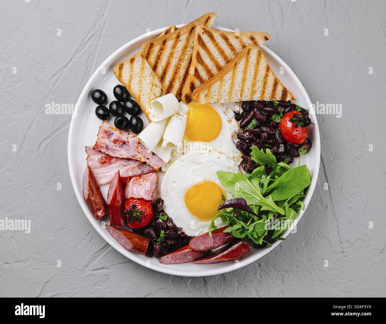 Nourriture, vue aérienne d'une assiette copieux avec œufs, bacon, pain grillé et légumes frais Banque D'Images