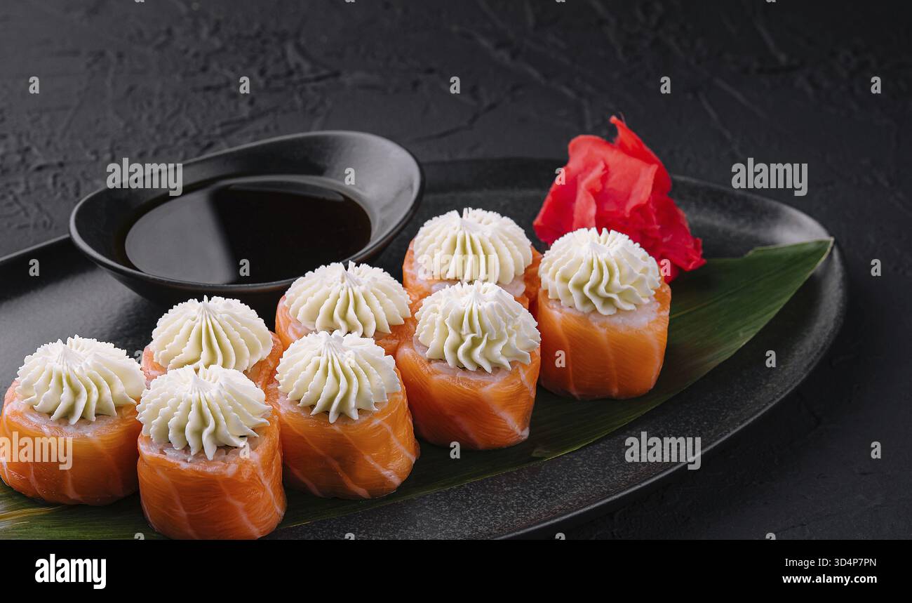 Nourriture, Sushi de Philadelphie avec fromage de Philadelphie sur assiette asiatique noire Banque D'Images