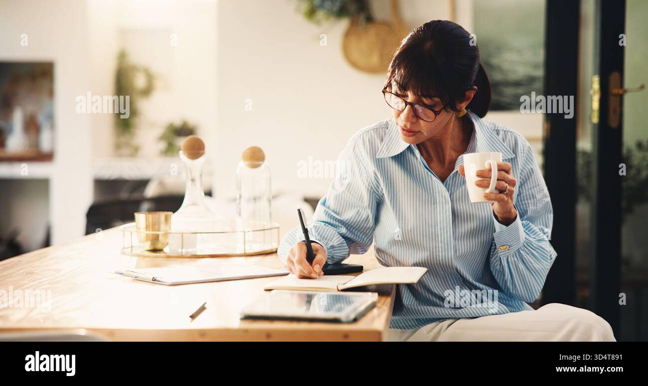 Femme, écriture et cahier avec café à la maison pour la planification, le rappel financier et le calendrier de paiement. Personne mature, boisson et notes pour le ménage Banque D'Images
