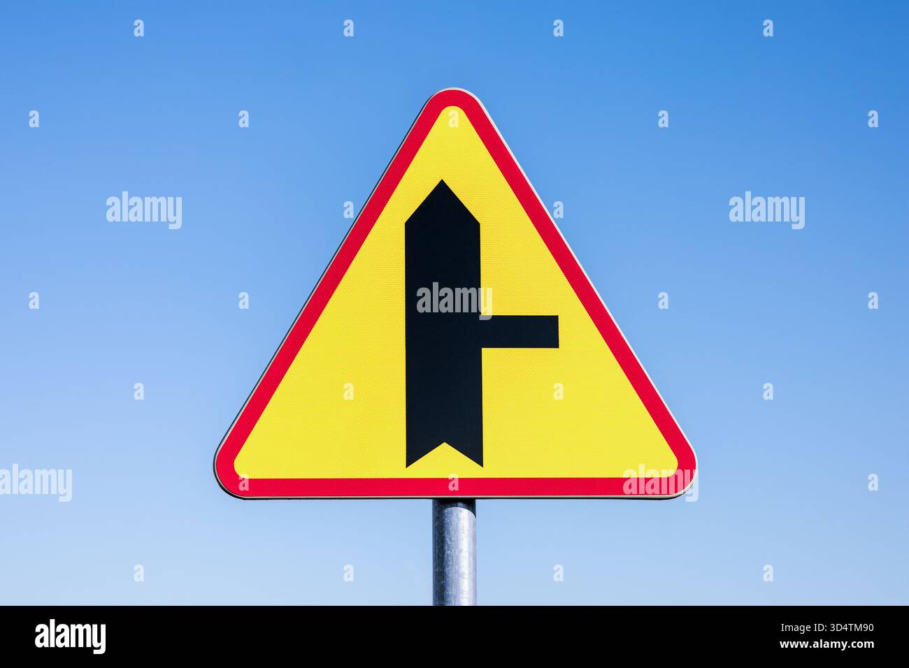 Intersection avec une route latérale sur la droite - panneau routier polonais sur un fond de ciel bleu. Banque D'Images