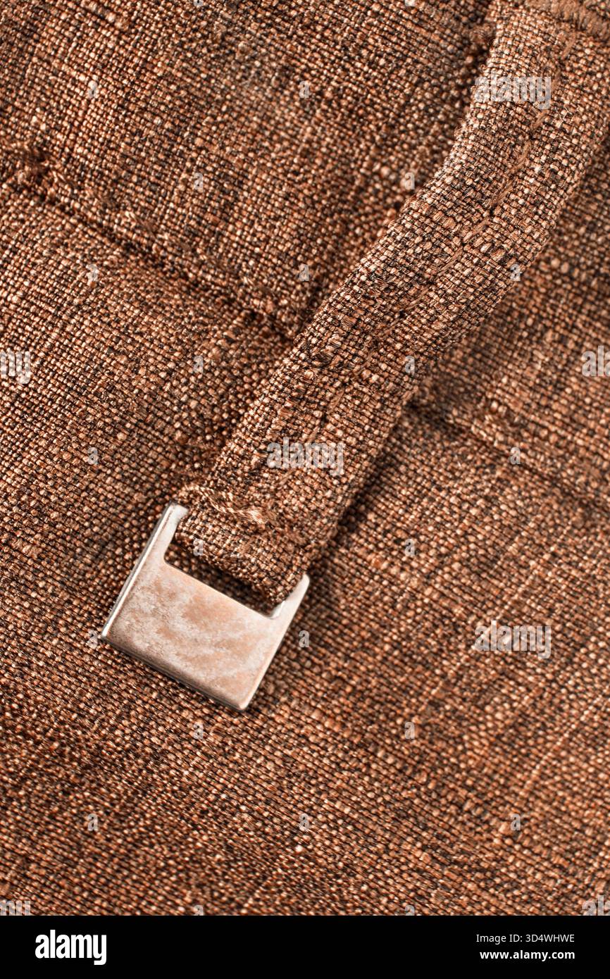 Boucle de ceinture pantalon en tissu marron avec plaque signalétique en métal vierge gros plan Banque D'Images