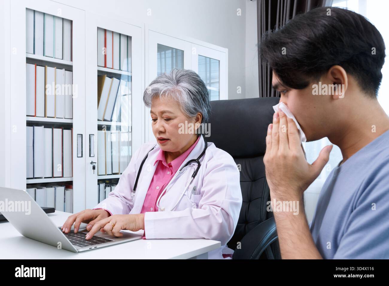 Médecin spécialiste senior des allergies féminines en asie consultant le patient masculin dans la clinique hospitalière moderne, consultation médicale et conseils de traitement, soins de santé Banque D'Images