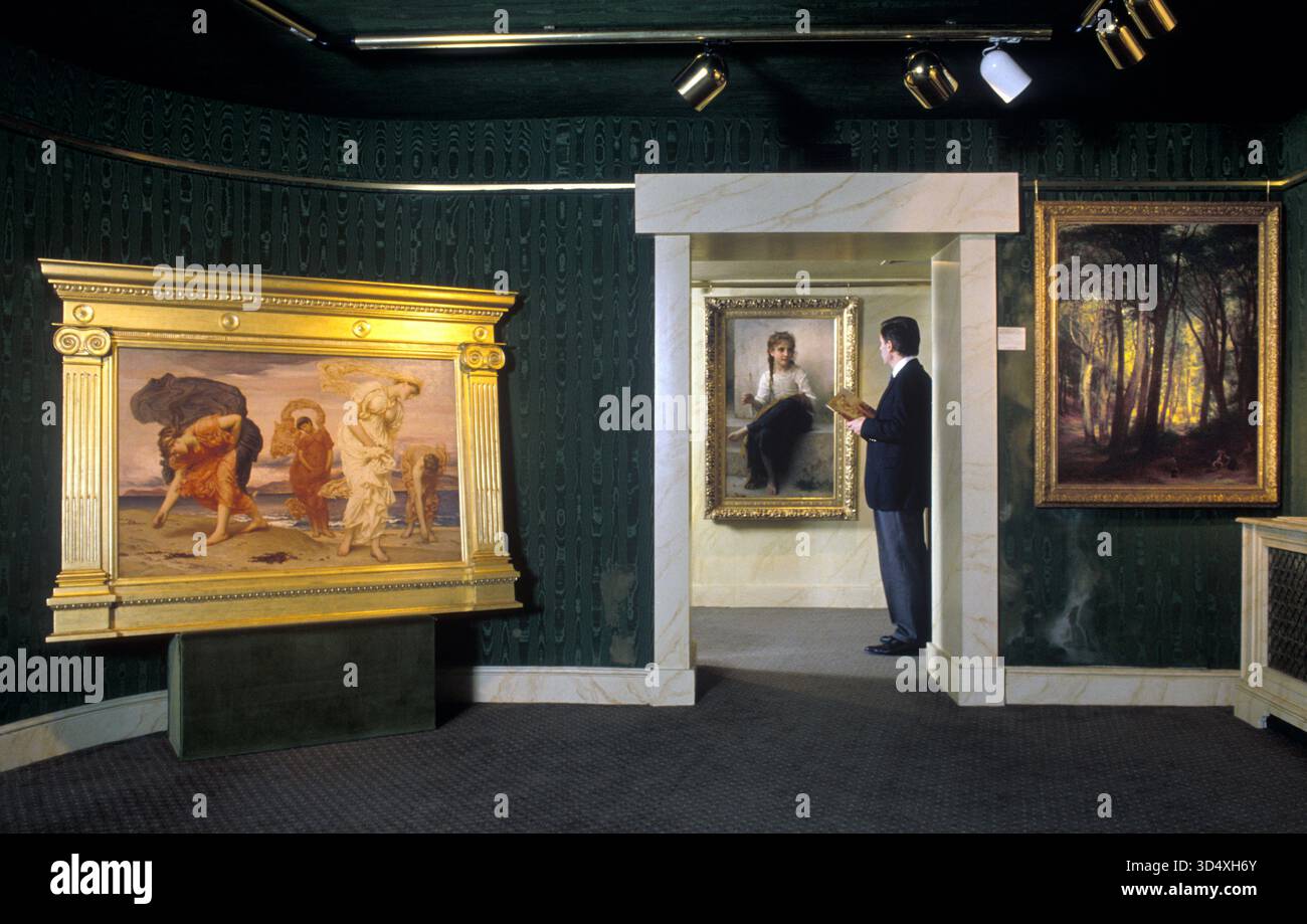 Marchand d'art 1990s en galerie la Galerie d'art Belgravia Londres 1999 Royaume-Uni . (L) les filles grecques ramassant des pébbles par Lord Frederic Leighton HOMER SYKES Banque D'Images