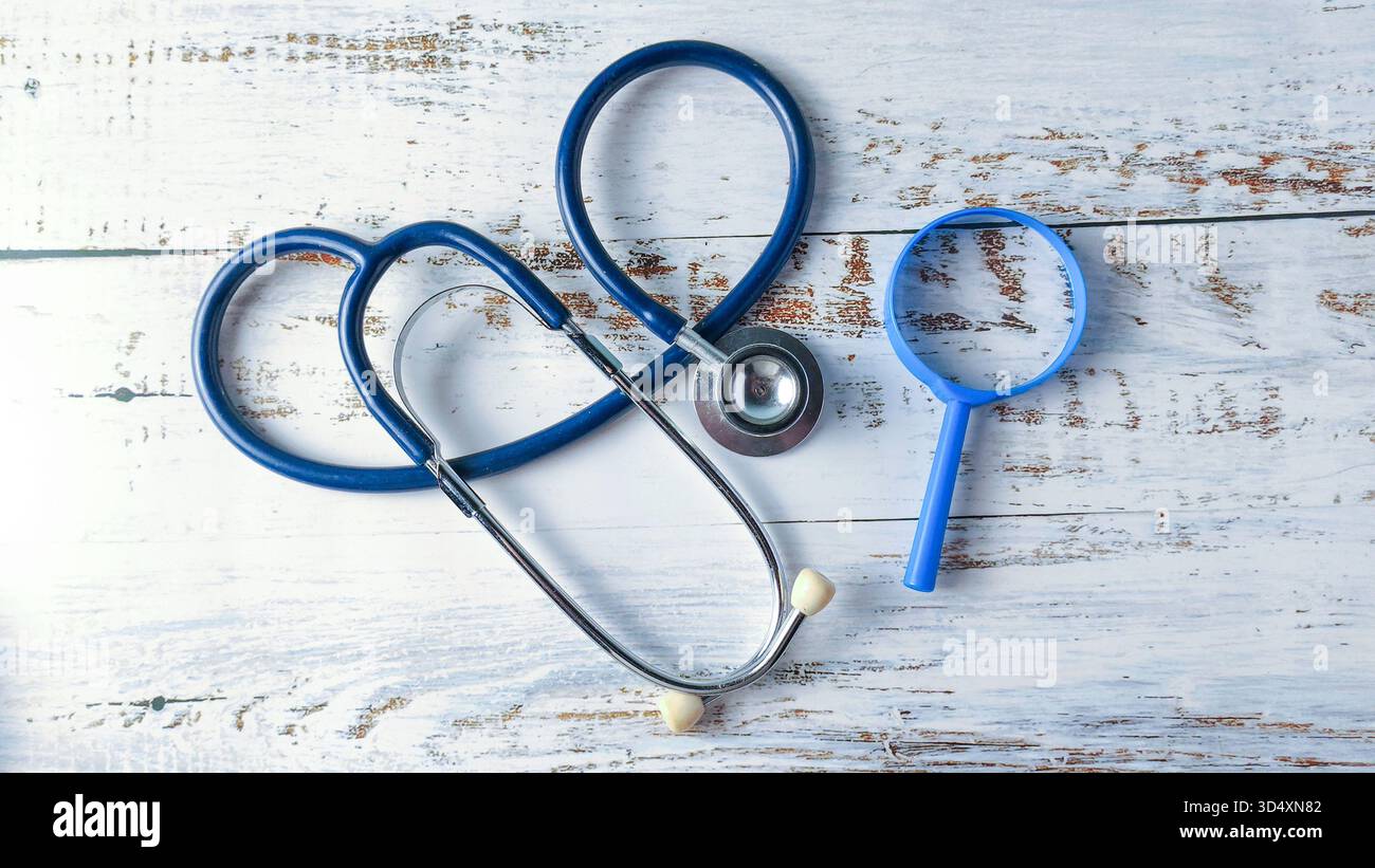 Stéthoscope et loupe sur une table en bois : recherche médicale, investigation médicale et outils de diagnostic Banque D'Images
