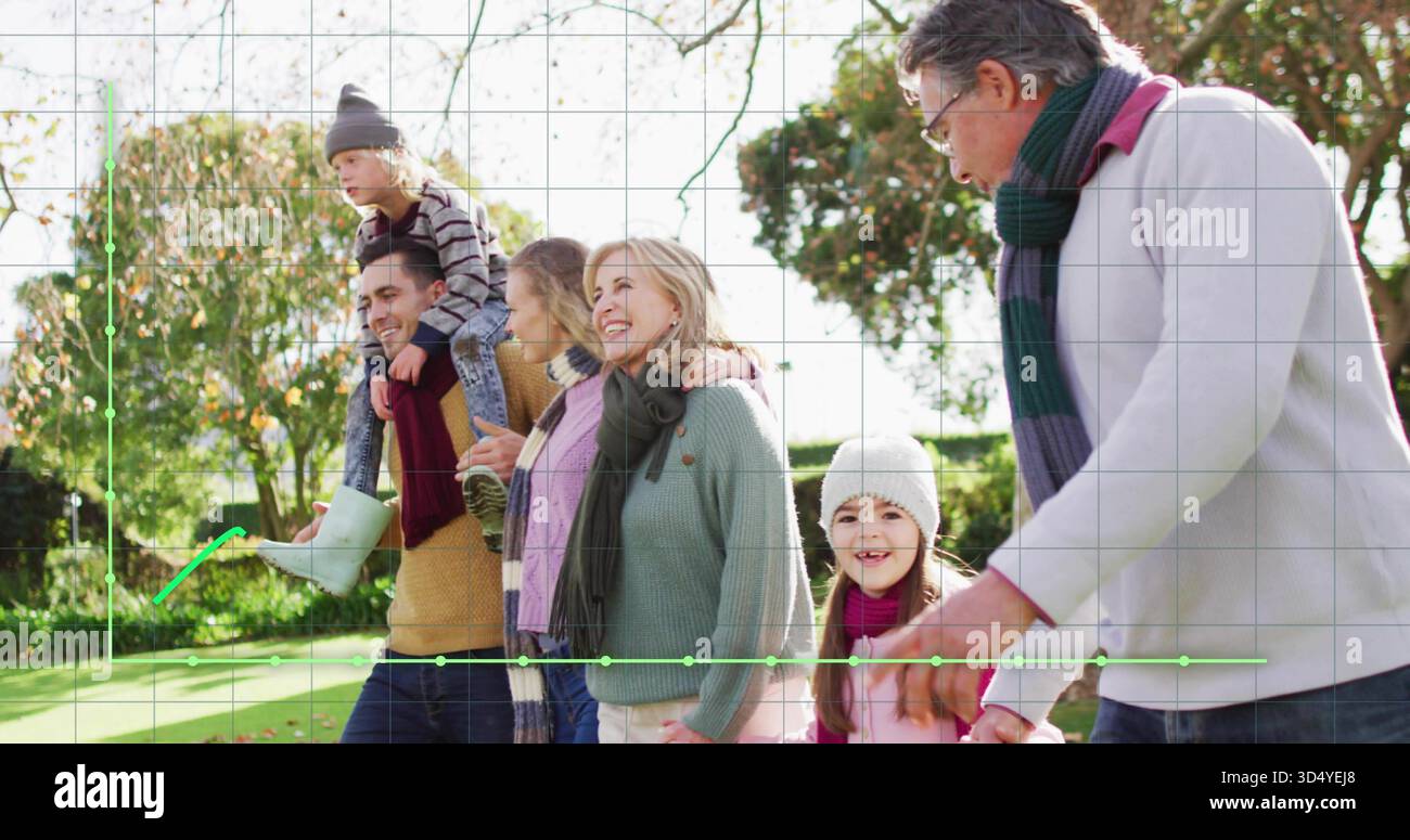 Marcher famille de trois générations portant manteaux et foulards dans le parc ensoleillé, montrant la superposition de grille Banque D'Images