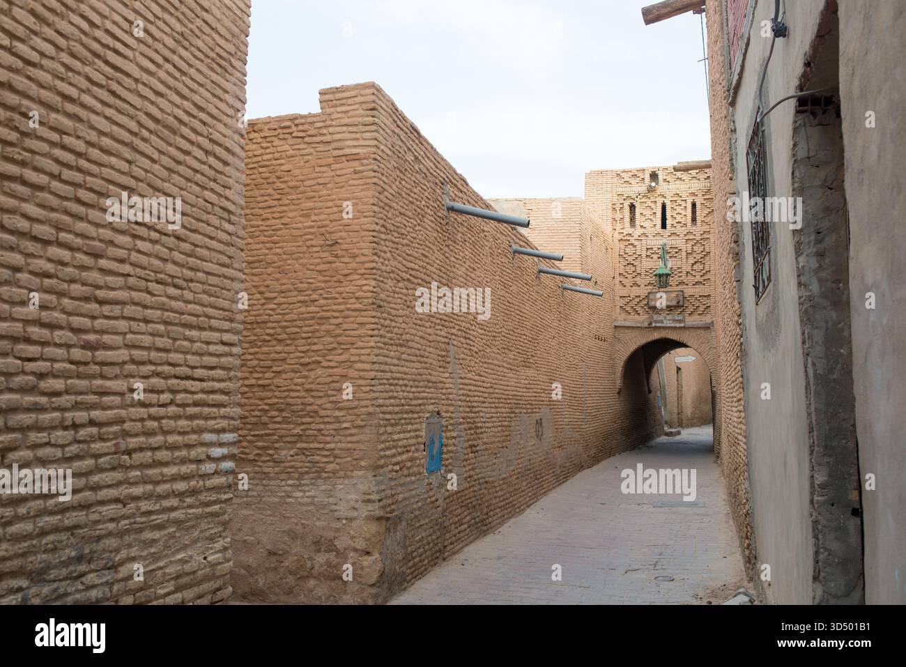 Rue avec arcs et hauts murs à Tozeur Medina. Tunisie Banque D'Images