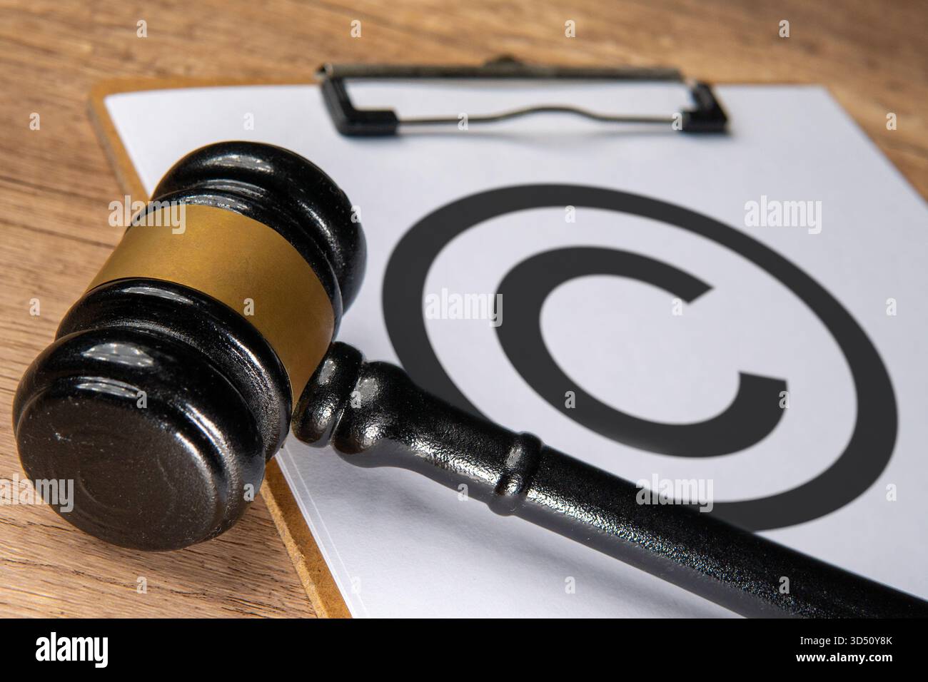 Gros plan du marteau d'un juge placé à côté d'un symbole de copyright sur un presse-papiers. Droit de la propriété intellectuelle, protection des droits d'auteur et droits légaux Banque D'Images