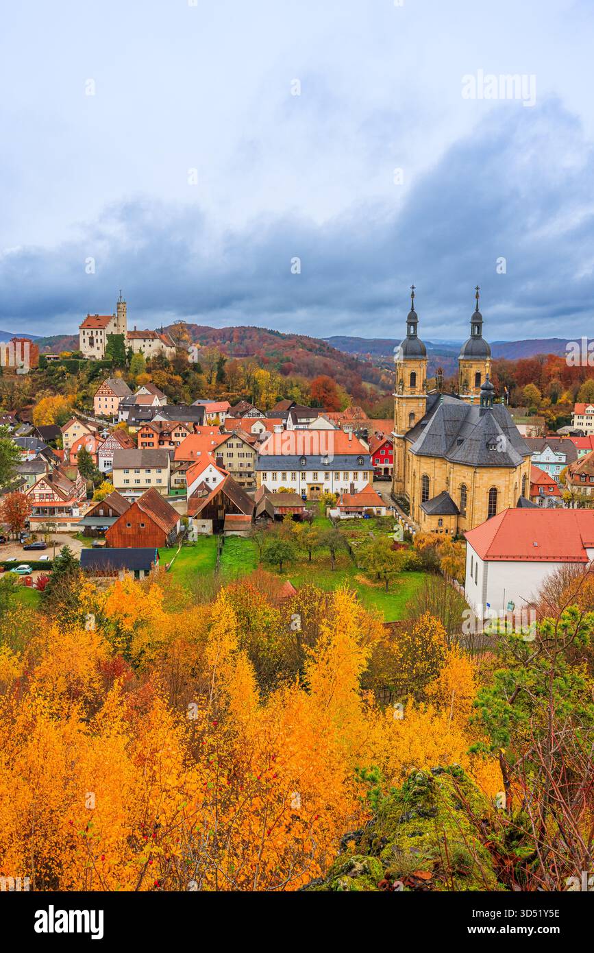 Image verticale du château de Gößweinstein en Suisse franconienne, Bavière, Allemagne, entouré par un feuillage d'automne vibrant sous un ciel fortement couvert. Banque D'Images