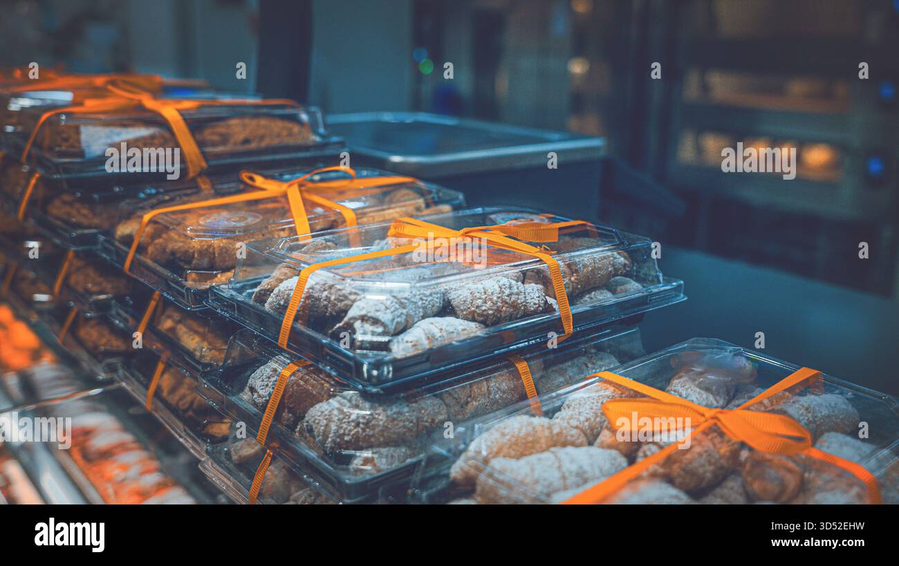 Produits de boulangerie frais des fêtes dans un emballage transparent avec ruban jaune sur un comptoir de magasin Banque D'Images