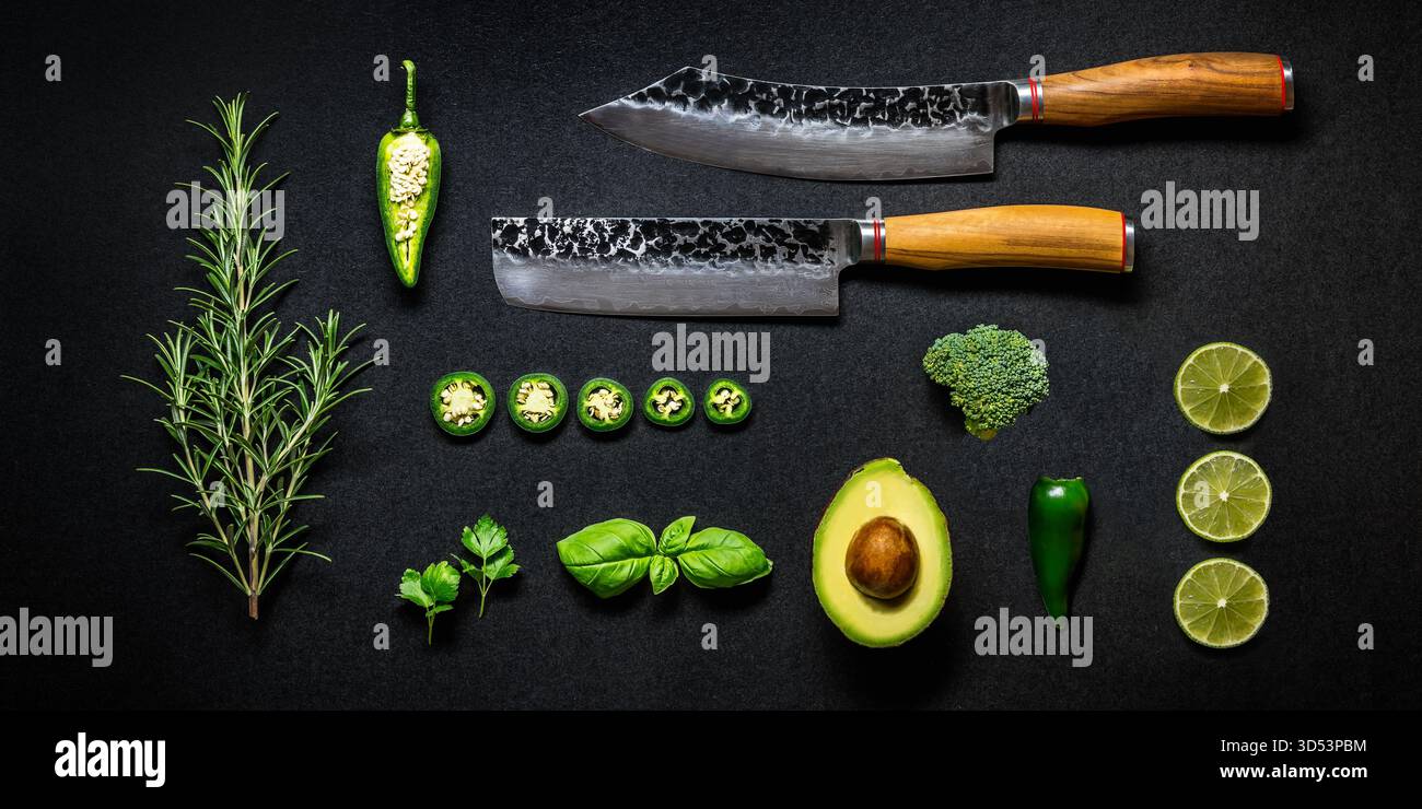 Légumes verts et couteaux sur fond noir, nature morte de nourriture Banque D'Images