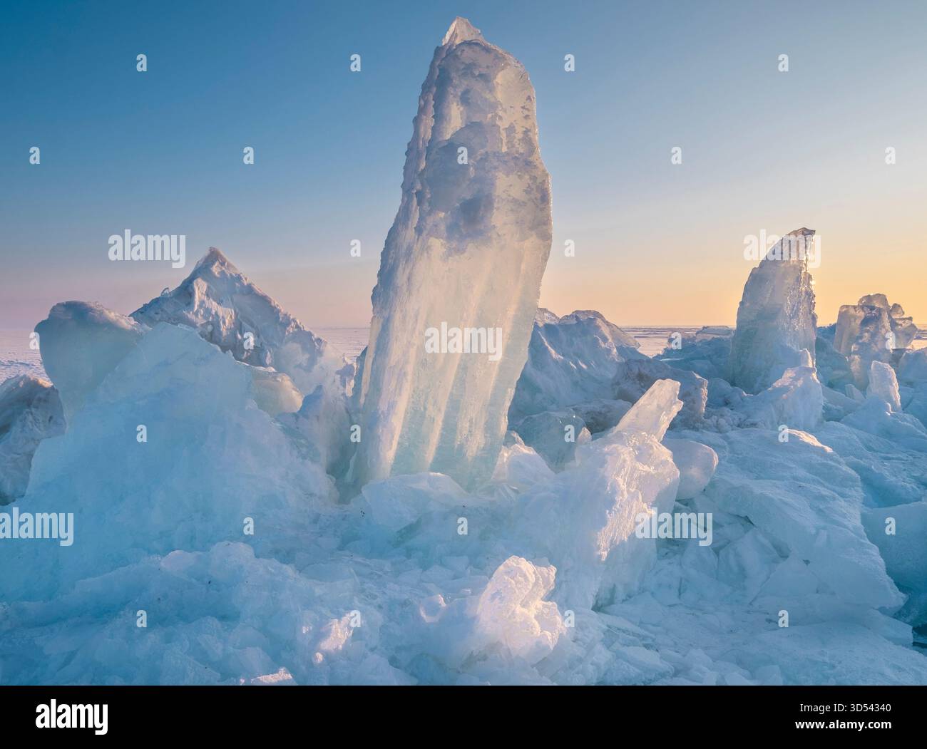 Majestueux hummocks de glace sur un lac gelé au coucher ou au lever du soleil. La merveille naturelle de l'hiver Banque D'Images