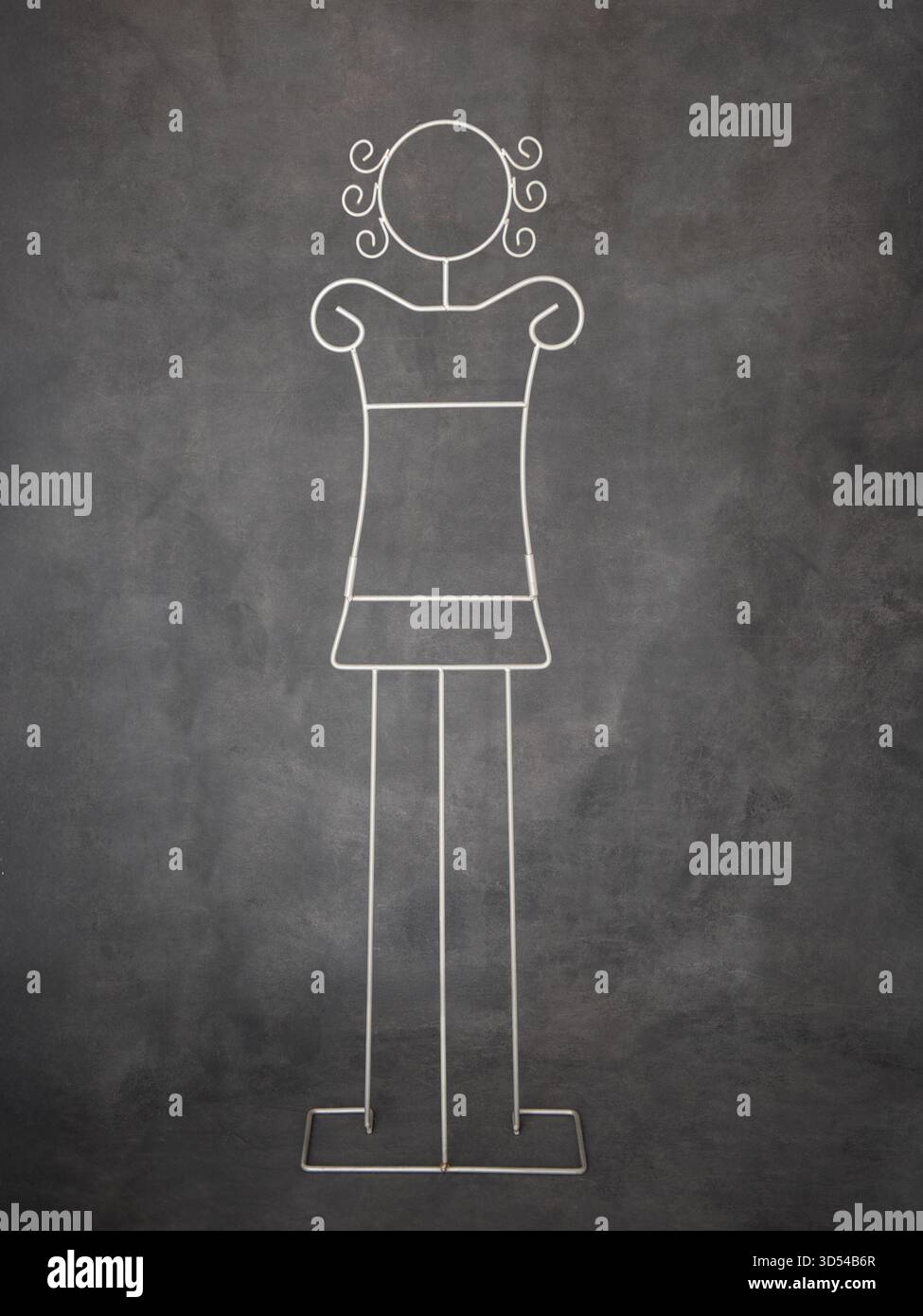 Sculpture en fil de fer représente une figure féminine stylisée, mettant en valeur le design artistique avec un fond sombre texturé, mettant en valeur la créativité et les artisans Banque D'Images