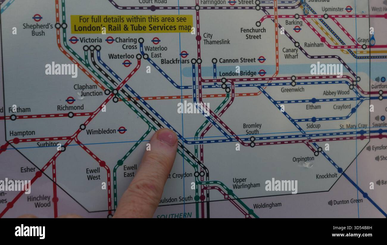 Un banlieue examine une carte du réseau ferroviaire de Londres. Banque D'Images