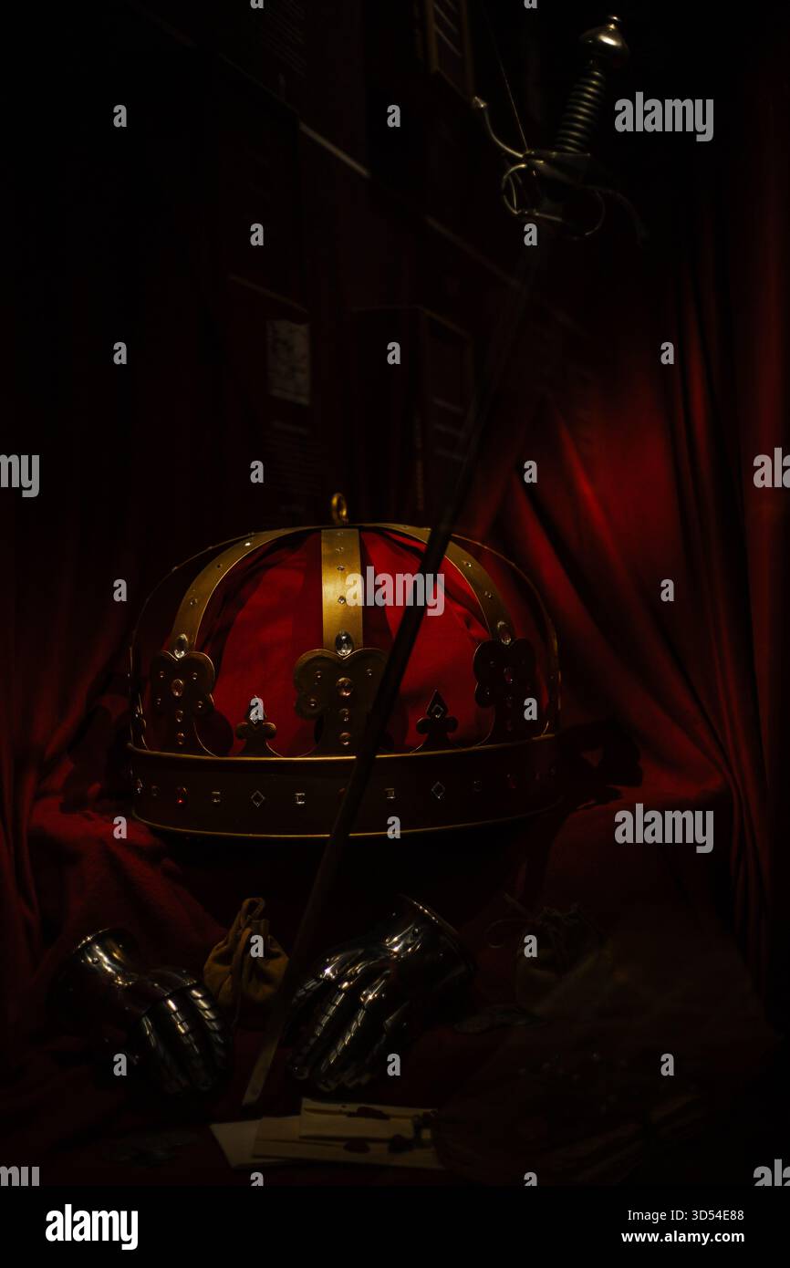 Couronne médiévale, épée, et une vieille lettre disposée sur une table en bois, créant une scène royale et historique avec des textures antiques dramatiques. Banque D'Images