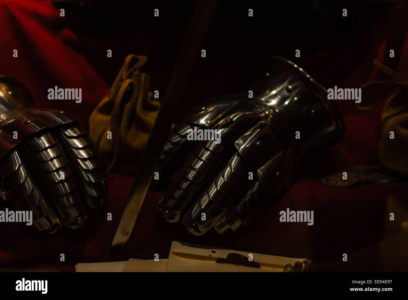 Couronne médiévale, épée, et une vieille lettre disposée sur une table en bois, créant une scène royale et historique avec des textures antiques dramatiques. Banque D'Images