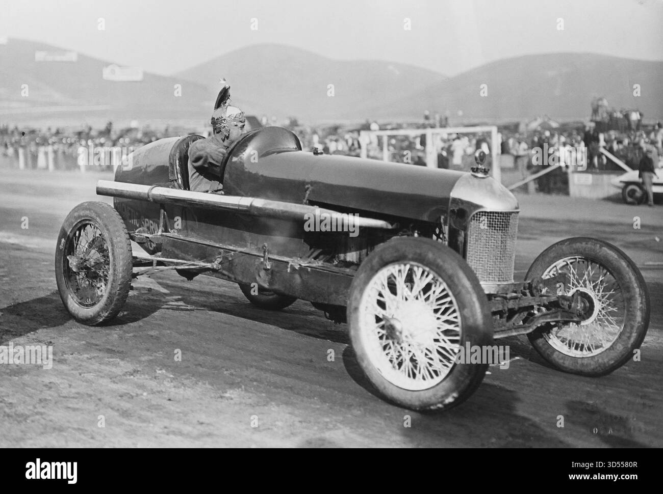 Voiture de course modèle ancien avec conducteur assis sur le circuit Banque D'Images