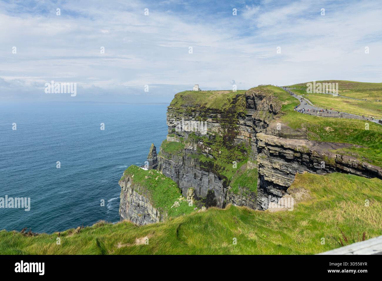 La tour d'O'Brien   construite en 1835   est vue au loin sur les falaises de Moher, à l'extrémité sud-ouest de la région de Burren en Irlande. Banque D'Images