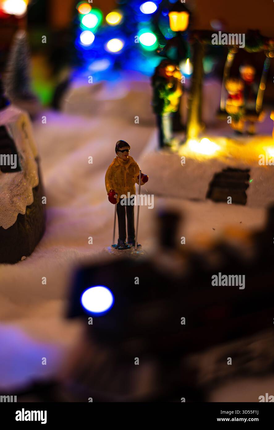Une belle scène de village de Noël miniature avec des lumières festives et de minuscules figurines créant une atmosphère de vacances chaleureuse avec bokeh et colorfu éclatants Banque D'Images