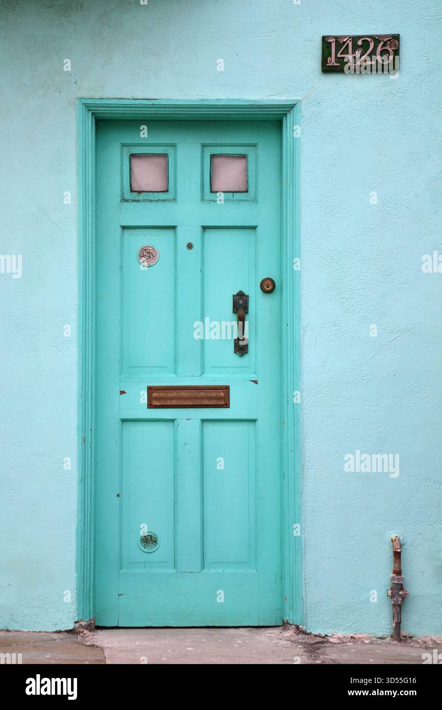 Porte d'entrée vert menthe avec panneaux de fenêtre roses et la maison numéro 1426 à San Francisco avec des lignes épurées et une palette de couleurs pastel douce Banque D'Images