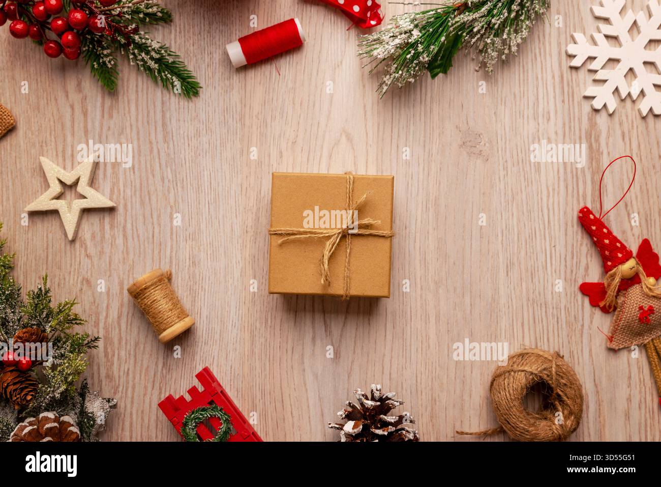 Minimaliste plat de Noël avec une boîte-cadeau enveloppée entourée de décorations festives, idéal pour les campagnes de vacances, les promotions de cadeaux et les pro saisonniers Banque D'Images