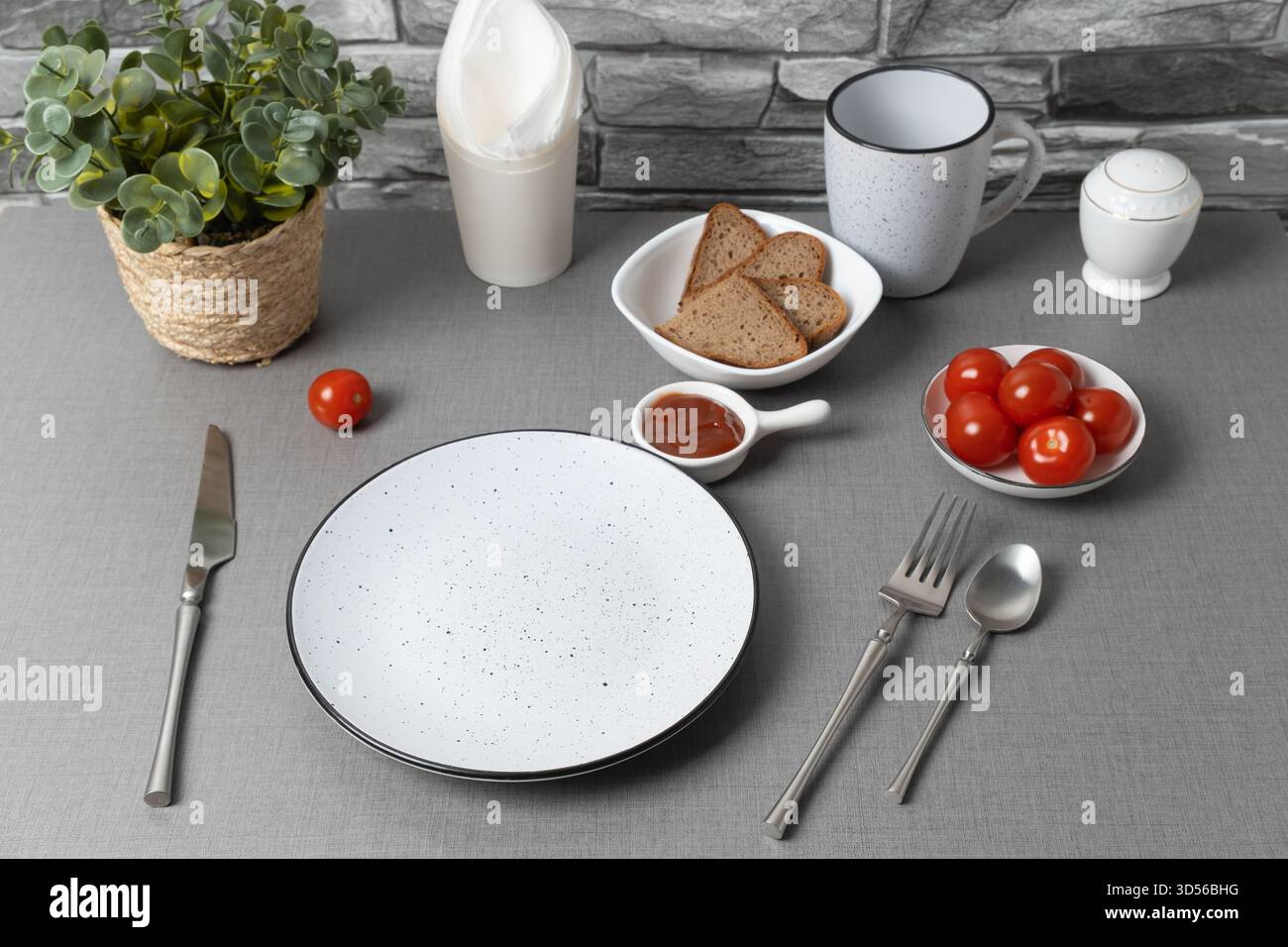 Table simple avec pain, tomates et condiments pour un repas décontracté Banque D'Images