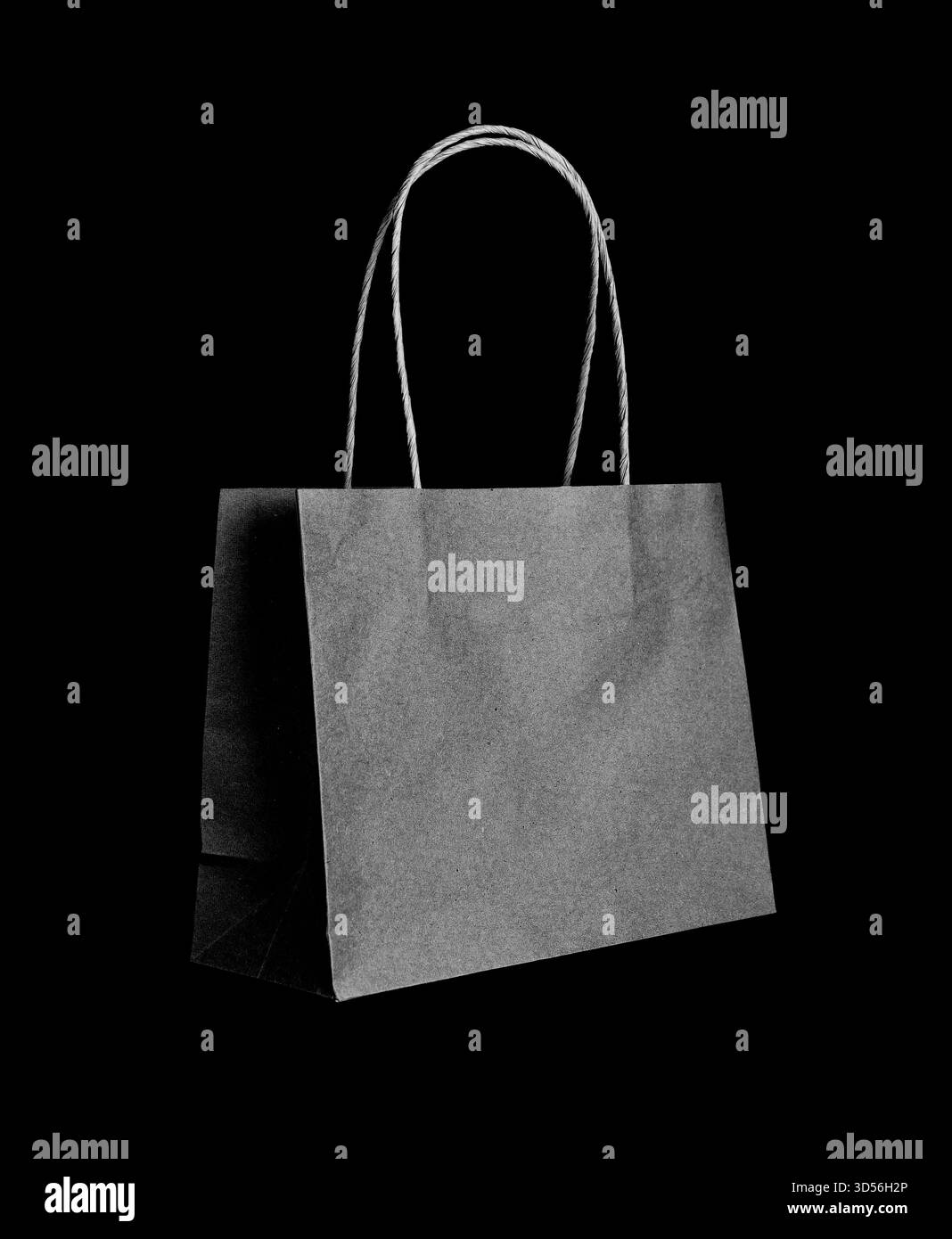 Sac à provisions en papier noir sur fond sombre, concept minimal de consumérisme et de vente au détail, symbole de la mode de luxe, shopping personnel et Black Friday s. Banque D'Images