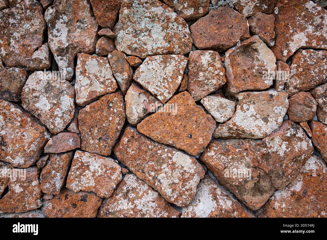 Un mur fait de roches avec une substance blanche dessus. Le mur est fait de nombreuses roches de tailles différentes Banque D'Images