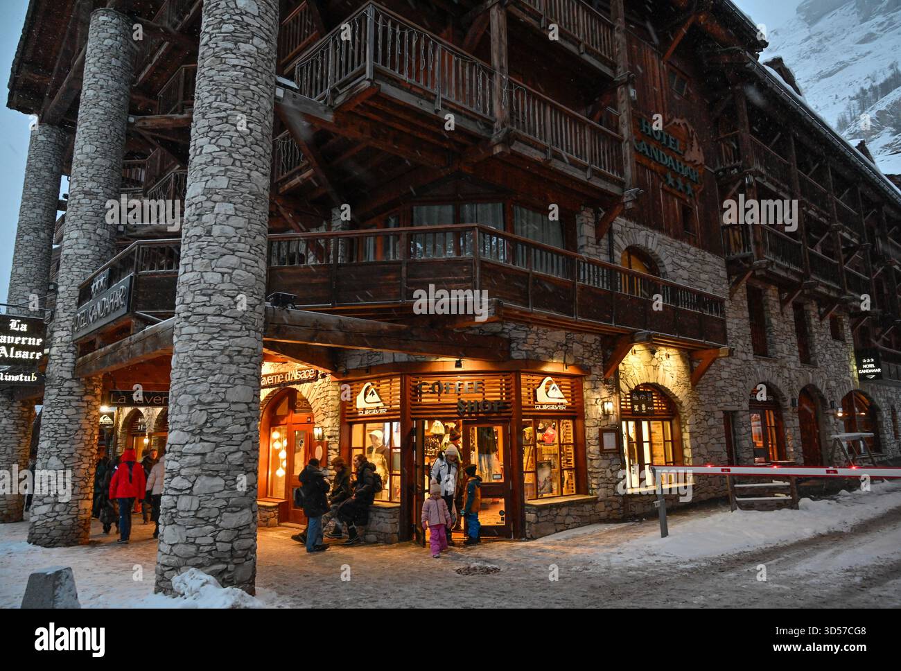 Val-d'Isère (Alpes françaises) : touristes dans une rue enneigée de la station de ski, en bas de l'hôtel trois étoiles Kandahar. Café vif-argent Banque D'Images