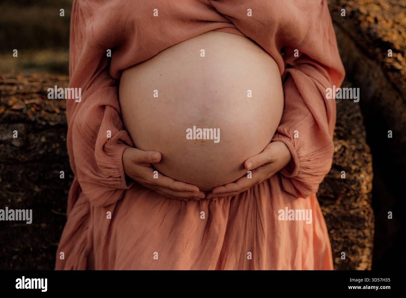 Gros plan d'une femme enceinte tenant son ventre à l'extérieur Banque D'Images