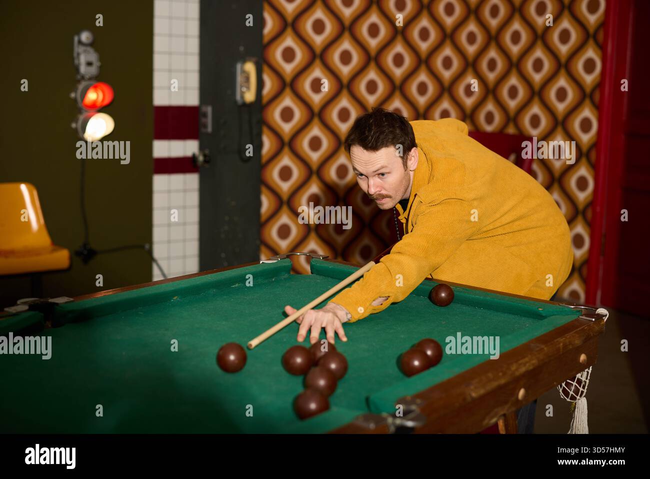 Jouer au billard dans une salle à thème rétro aux couleurs vives Banque D'Images