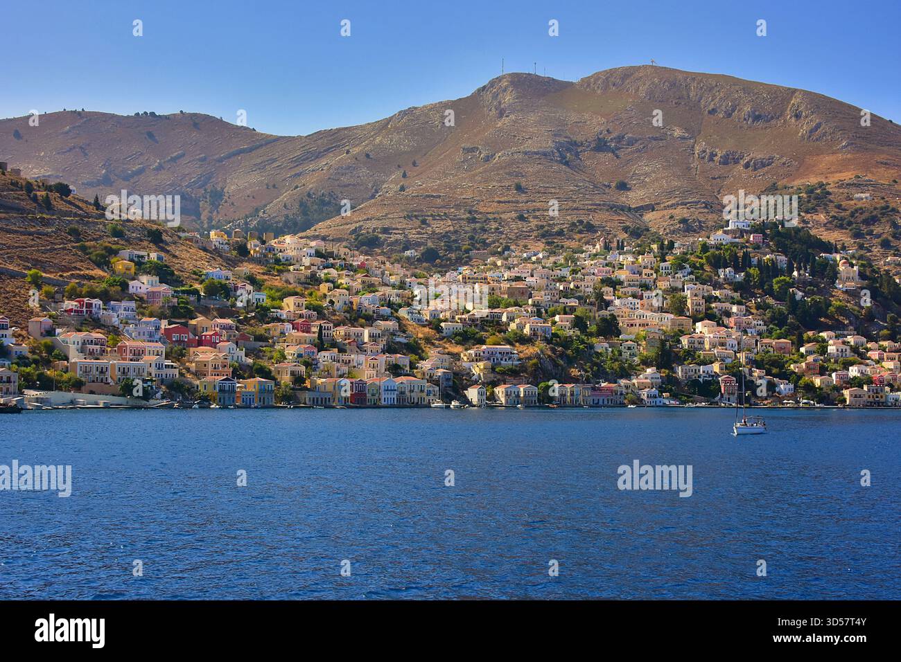 Bateau ancré en mer avec Symi Town en arrière-plan, Symi, Grèce Banque D'Images