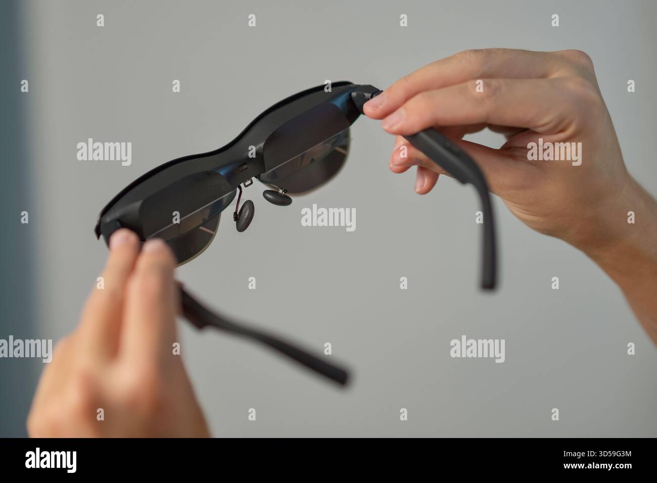 Gros plan des mains tenant des lunettes antidérapantes intelligentes. Concept de technologie portable, de dispositifs de réalité augmentée, d'innovation, de style de vie numérique et de technologie moderne. Banque D'Images