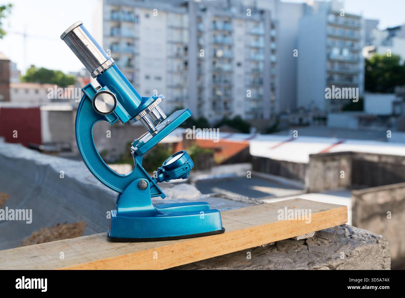 microscope de laboratoire sarcelle sur une planche de bois avec vue sur la ville Banque D'Images