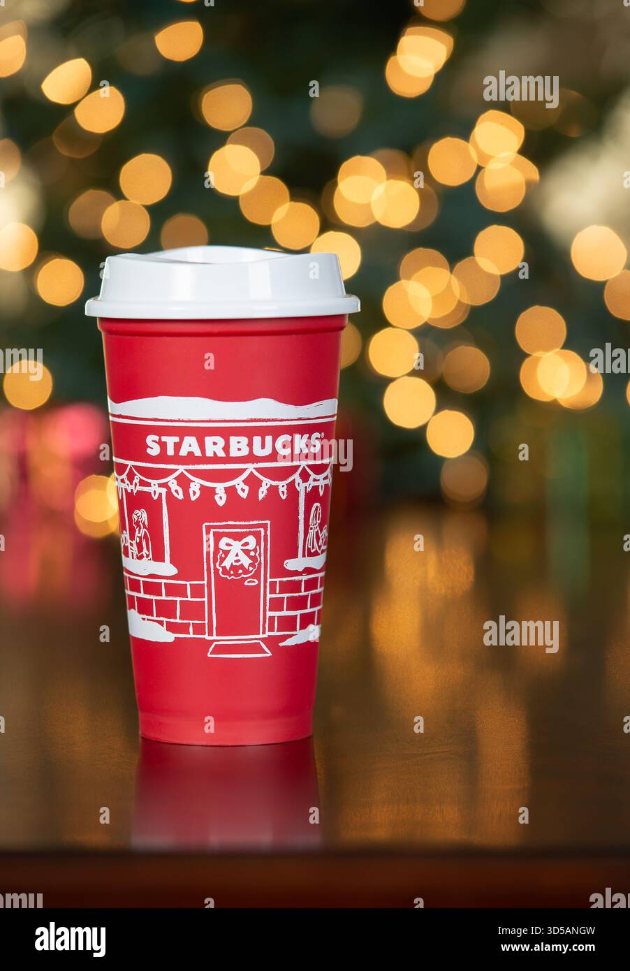 Dallas, Texas - 14 novembre 2025 : Starbucks boit dans la coupe rouge conçue en 2025, une coupe festive et réutilisable des fêtes. Affiché contre le bokeh BA de Noël Banque D'Images