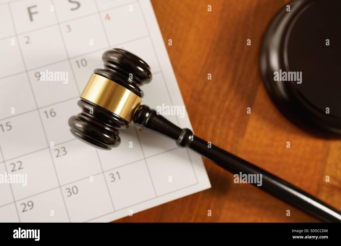 Loi, législation, justice et concept de temps avec une vue de dessus en gros plan d'un marteau de juge sur une page de calendrier. Métaphore du statut de prescription. Banque D'Images