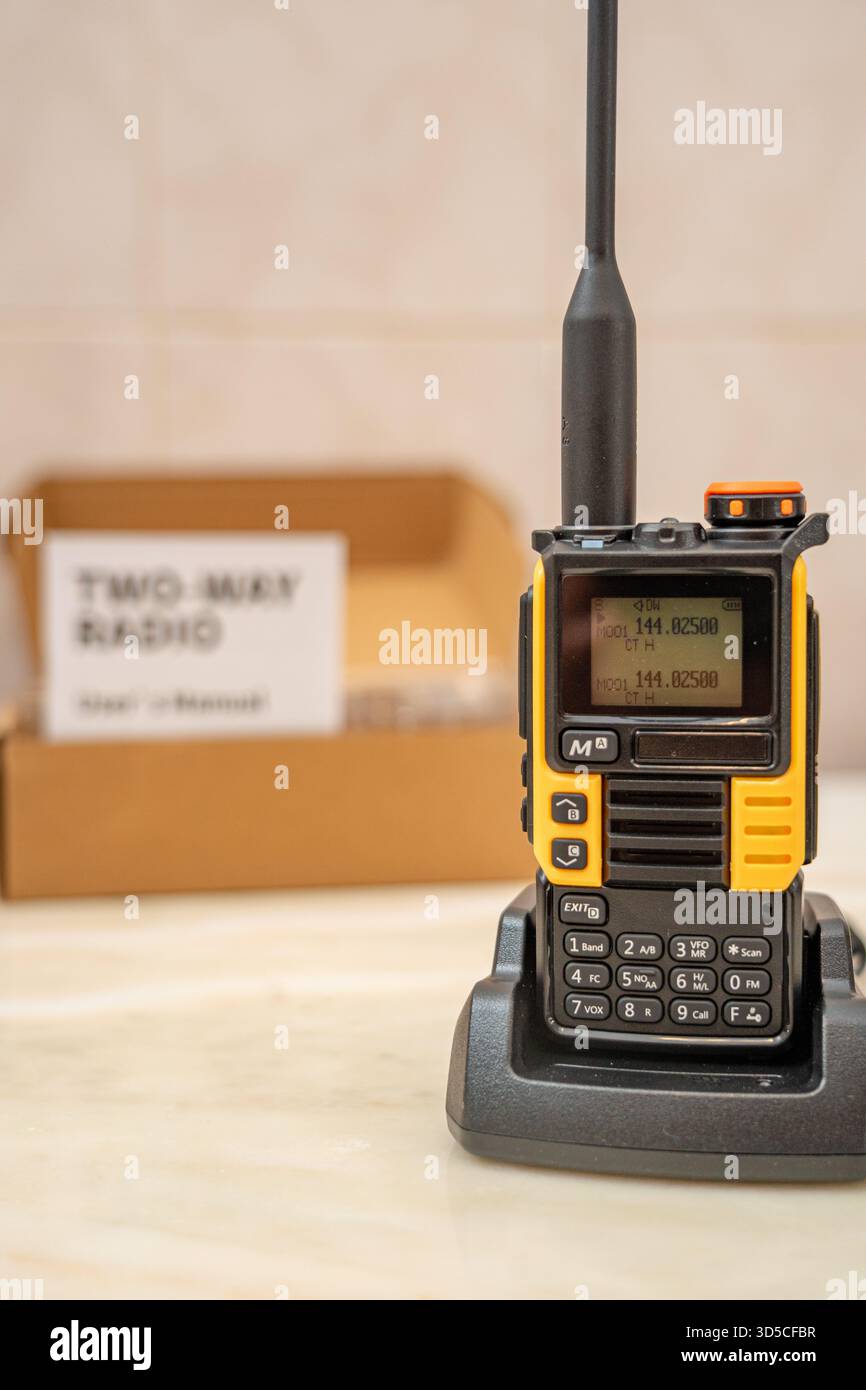 Radio talkie-walkie, de couleur jaune, sous le fond de l'emballage et du manuel d'instructions intitulé 'radio bidirectionnelle'.lisbonne-Portugal. Banque D'Images