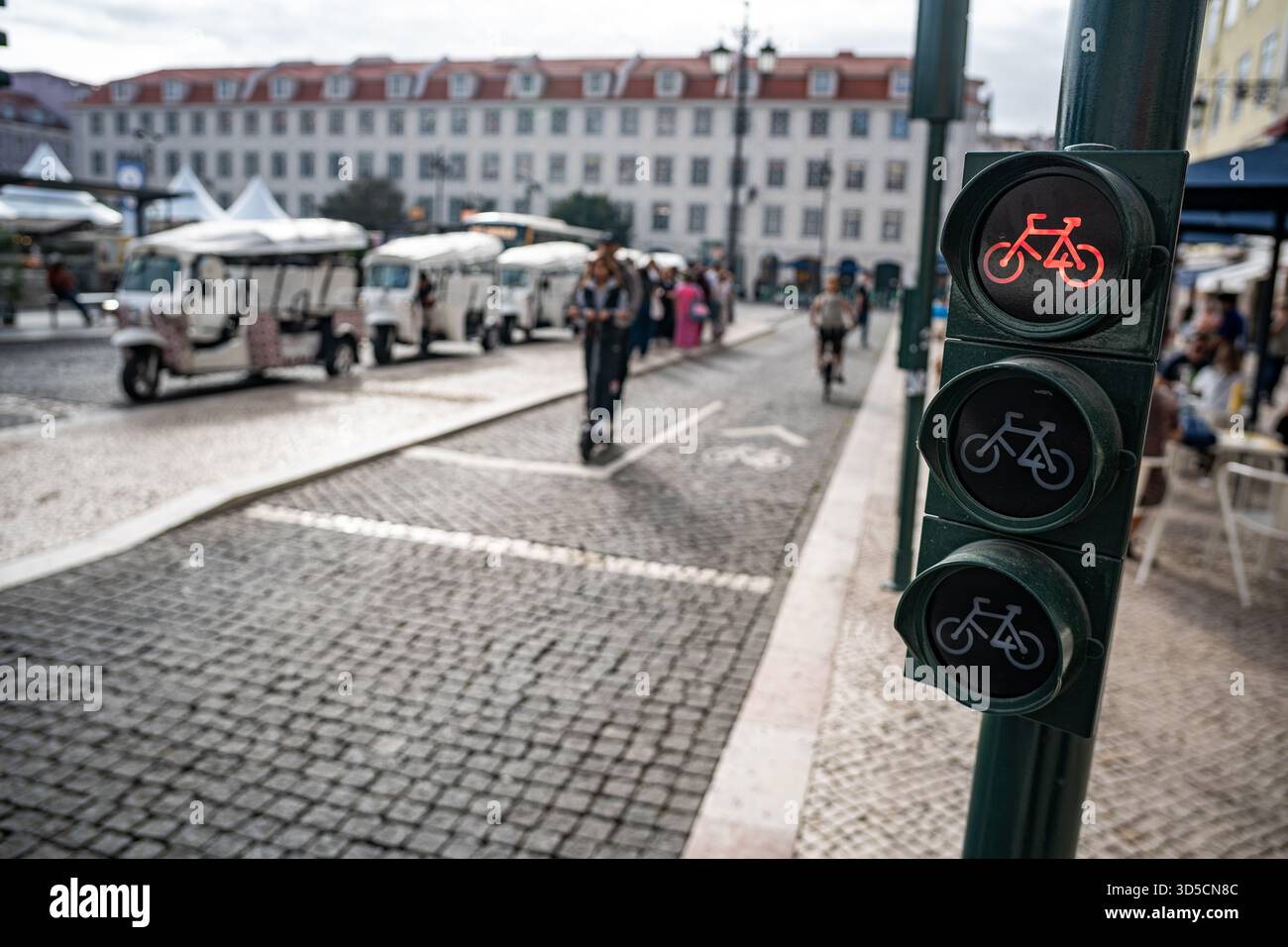 Un cycliste Glovo passant par un feu vert sur la piste cyclable, Lisbonne, Portugal. Banque D'Images