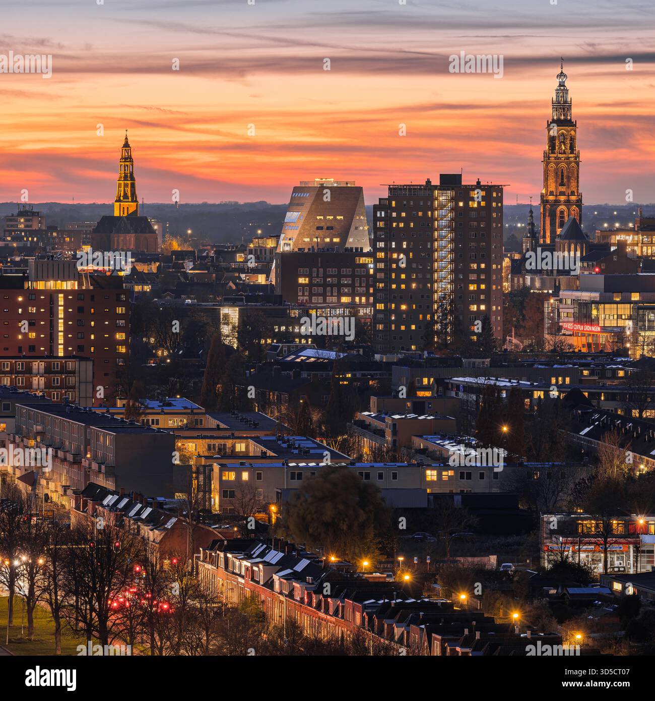 Vue imprenable sur les gratte-ciel de Groningen depuis le Tasmantoren juste après le coucher du soleil. Le ciel brille avec des teintes douces d'orange, de rose et de bleu, tandis que t Banque D'Images