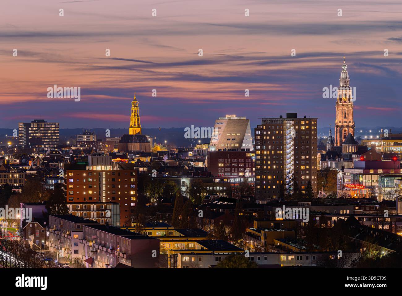 Vue imprenable sur les gratte-ciel de Groningen depuis le Tasmantoren juste après le coucher du soleil. Le ciel brille avec des teintes douces d'orange, de rose et de bleu, tandis que t Banque D'Images
