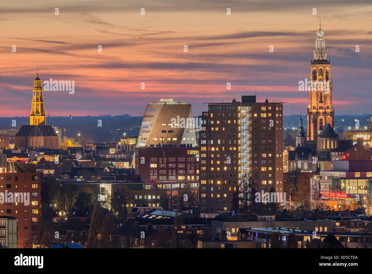 Vue imprenable sur les gratte-ciel de Groningen depuis le Tasmantoren juste après le coucher du soleil. Le ciel brille avec des teintes douces d'orange, de rose et de bleu, tandis que t Banque D'Images