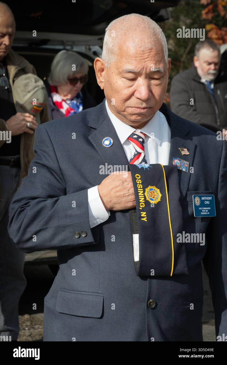 Un homme américain d'origine asiatique plus âgé actif dans la Légion américaine tient son chapeau au cœur lors de l'hymne national. Le parc Lasdon Day des vétérans. Banque D'Images