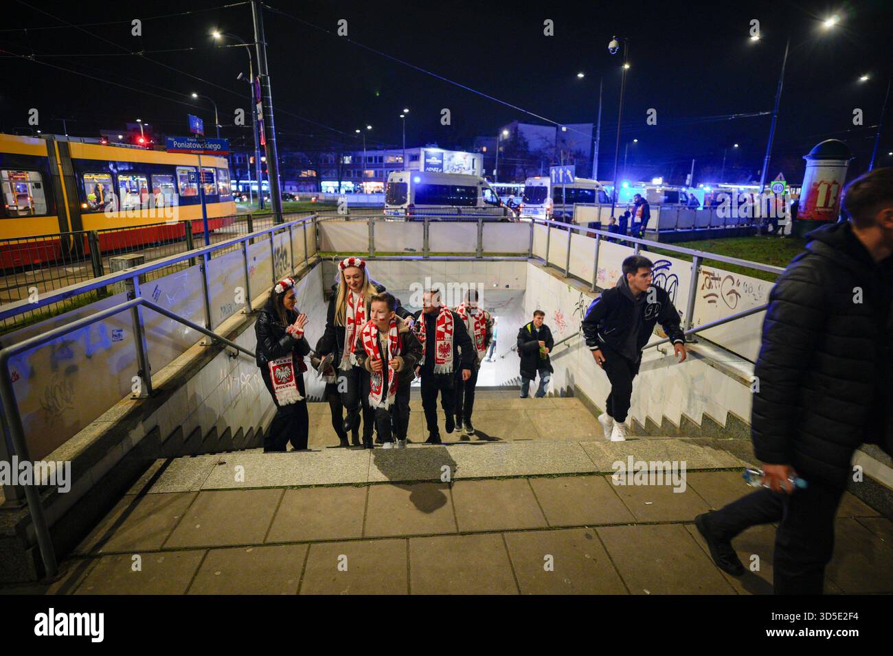 Varsovie, Pologne. 14 novembre 2025. Des fans sont vus arriver au stade national avec de nombreux camionnettes de police garées à l'arrière-plan sur cette photo de dossier prise à Varsovie, en Pologne, le 14 novembre 2025. Après le match entre la Pologne et les pays-Bas, le Polski Zwi?zek Pi?ki No?nej (PZPN) a publié une déclaration ferme condamnant le lancement de fusées éclairantes depuis les gradins pendant le match du PGE Narodowy de Varsovie, soulignant que de tels comportements sont inacceptables et illégaux, et que la sécurité de l'environnement du stade est leur priorité. (Photo de Jaap Arriens/Sipa USA) crédit : Sipa USA/Alamy Live News Banque D'Images