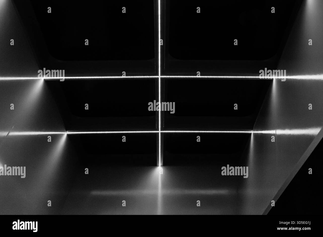 Intérieur d'ascenseur monochrome avec des lignes lumineuses brillantes créant un look d'architecture minimaliste moderne Banque D'Images