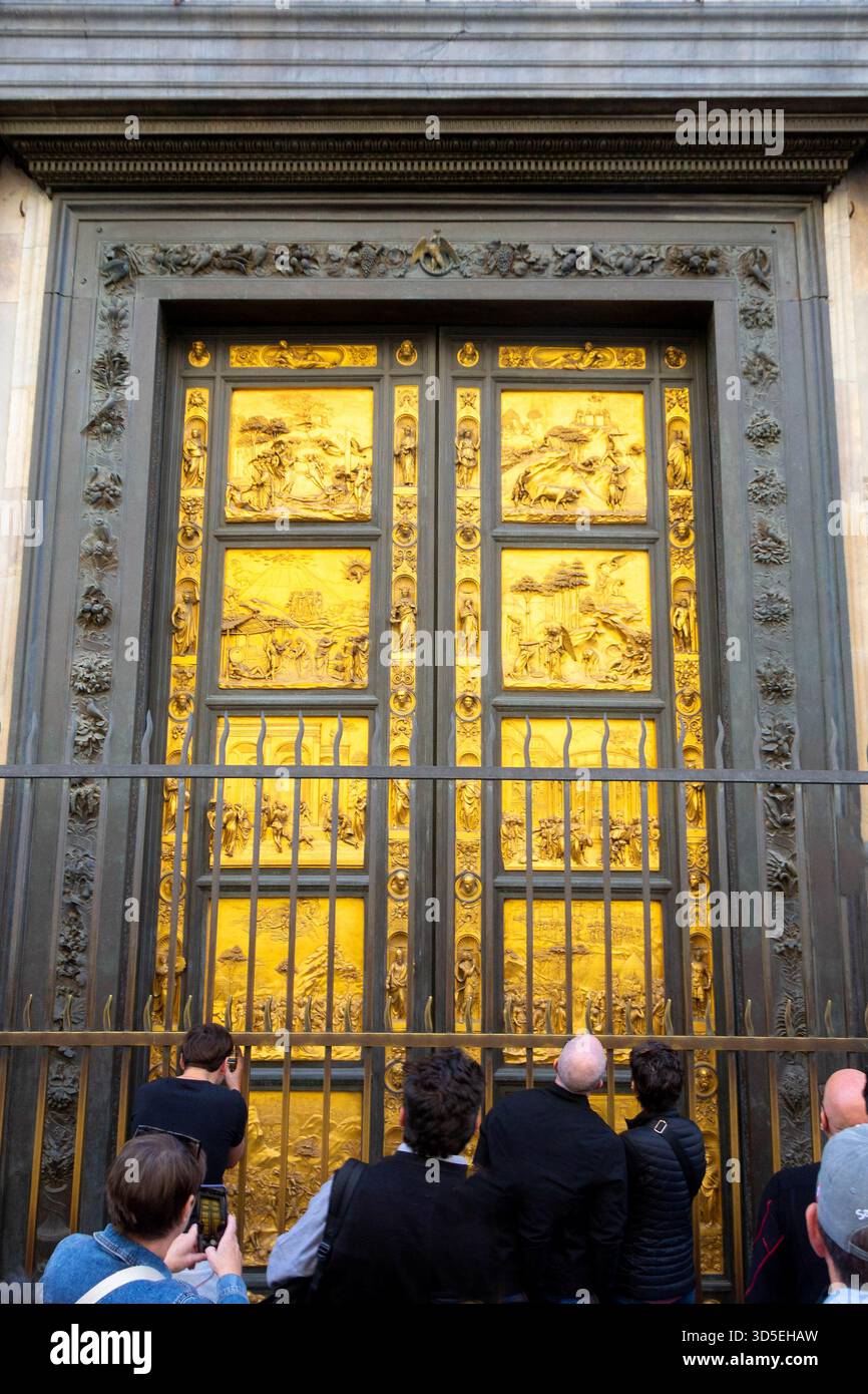Gros plan des portes dorées du Paradis sur le Baptistère de Florence, en Italie. Portes en bronze ornées de la Renaissance admirées par les touristes par une journée ensoleillée. Banque D'Images